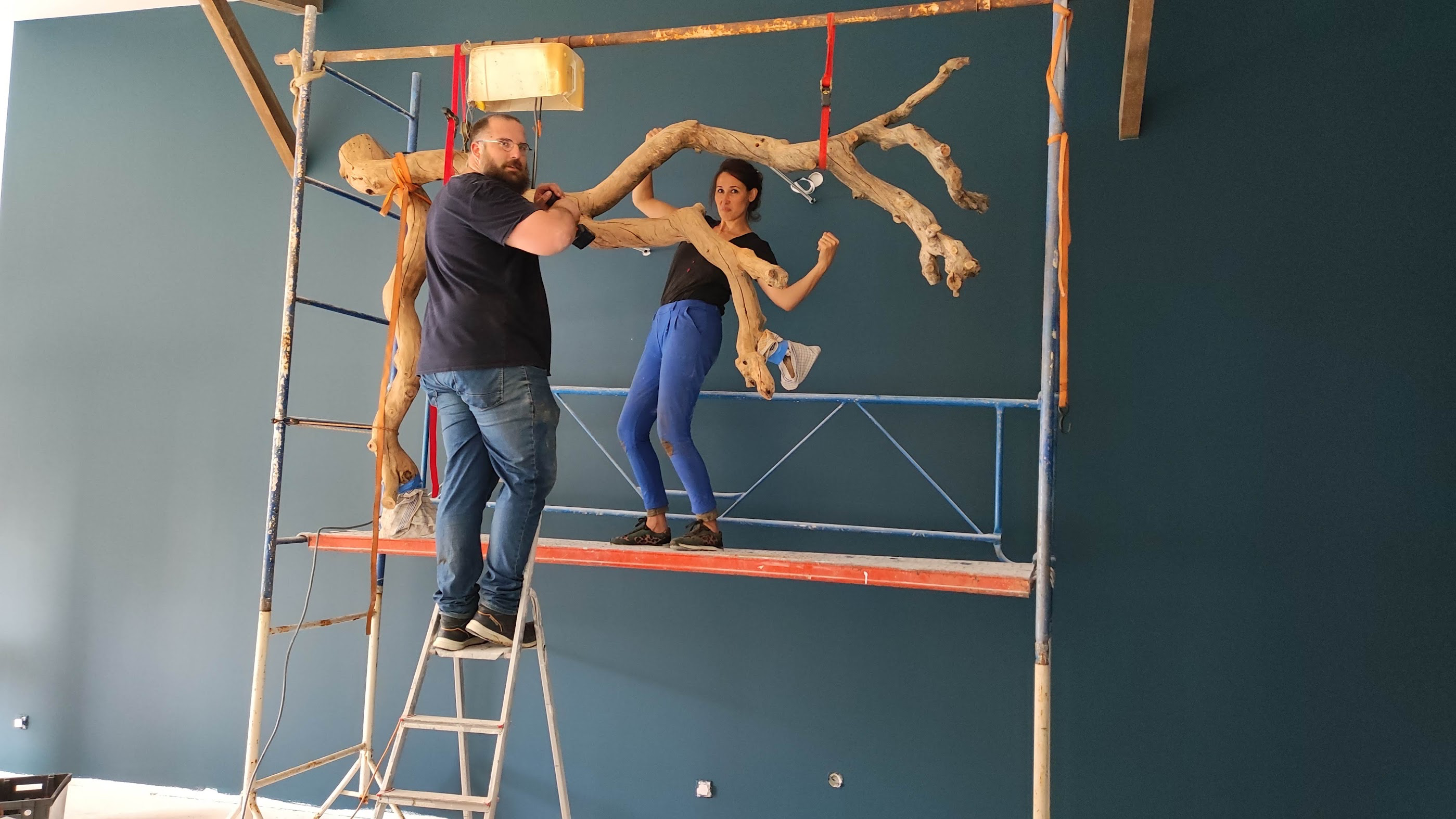 Nathanaëlle et son ami Gabriel installant le Pommier sur le grand mur bleu depuis l’échafaudage