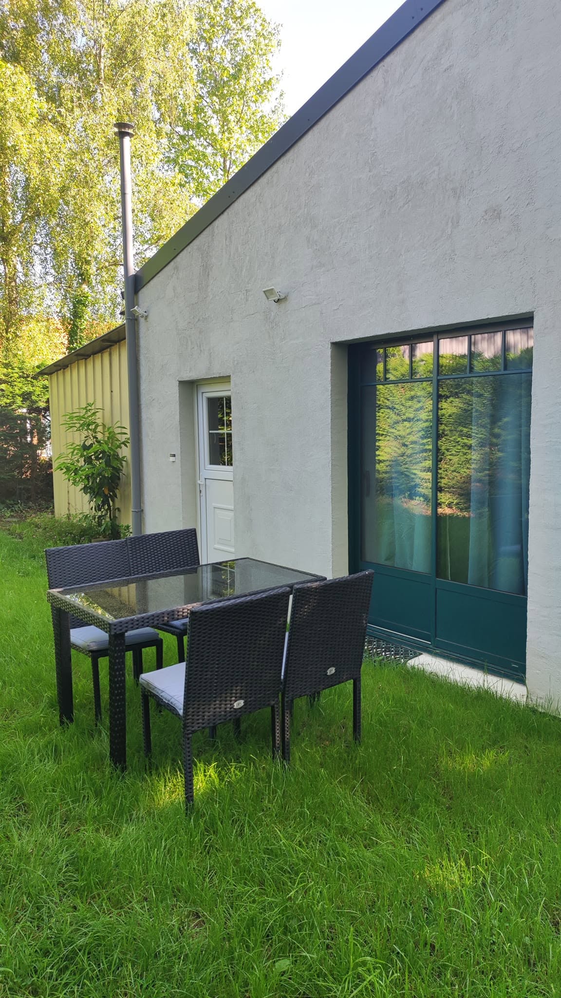 La terrasse avec table et chaises devant le Studio Grimm